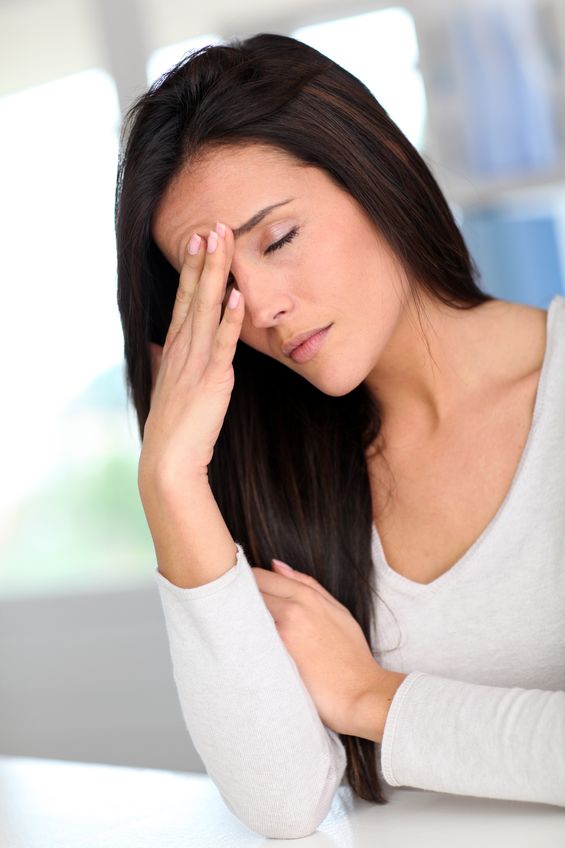 Adult female with head pain holding her forehead